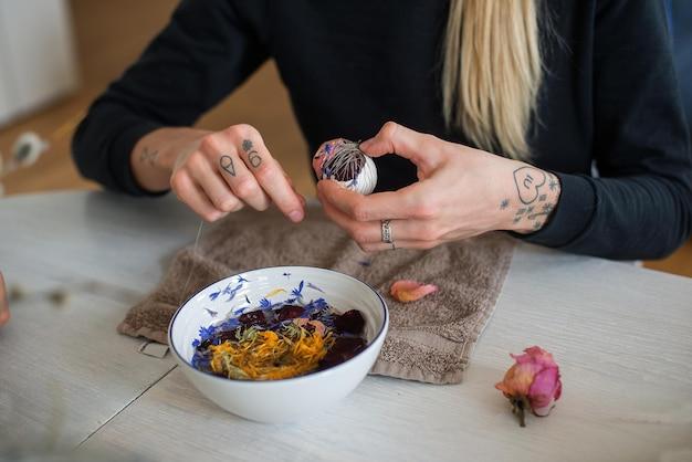 Person crafting with natural materials at a table.