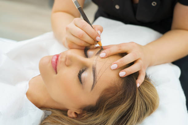 beautician-applying-permanent-makeup-to-woman-eyebrows